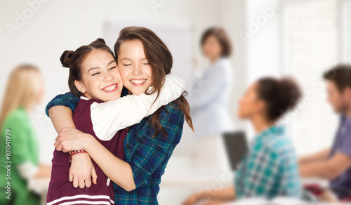 happy teenage student girls hugging at school