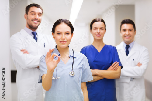 group of medics at hospital showing ok hand sign