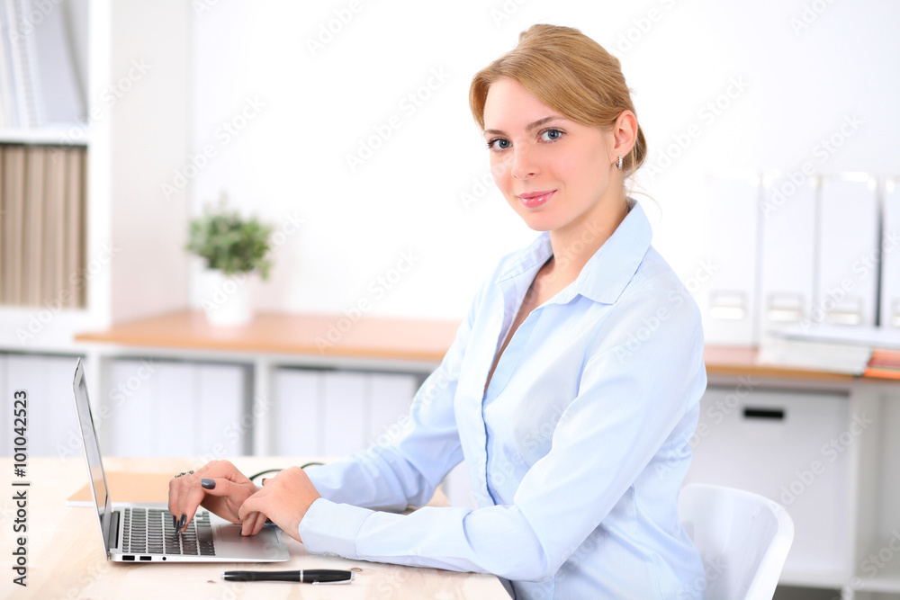 Young blonde business woman with laptop in the office. Business concept. Young blonde business woman with laptop in the office. Business concept.