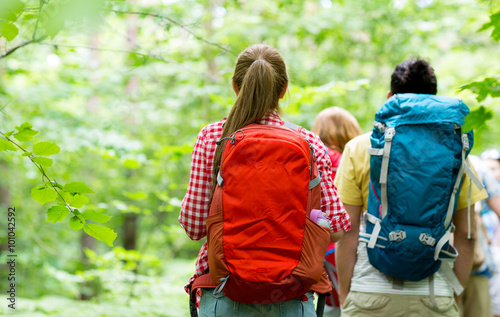 close up of friends with backpacks hiking