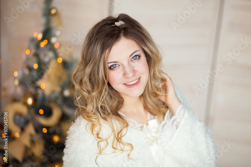 Beautiful girl in white dress sitting near a beautiful tree
