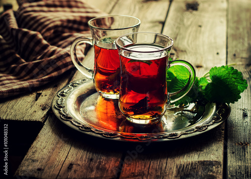 Tea with mint in the Arab style on wooden table.