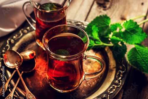 Tea with mint in the Arab style on wooden table.