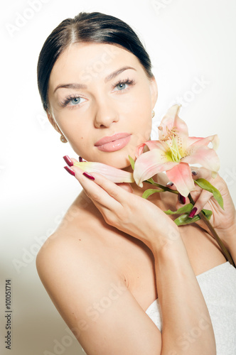 Beautiful lady with lilly flower. Perfect skin.