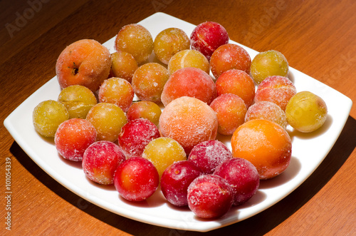 frozen fruits   Frozen plums and apricots in a bowl on a table