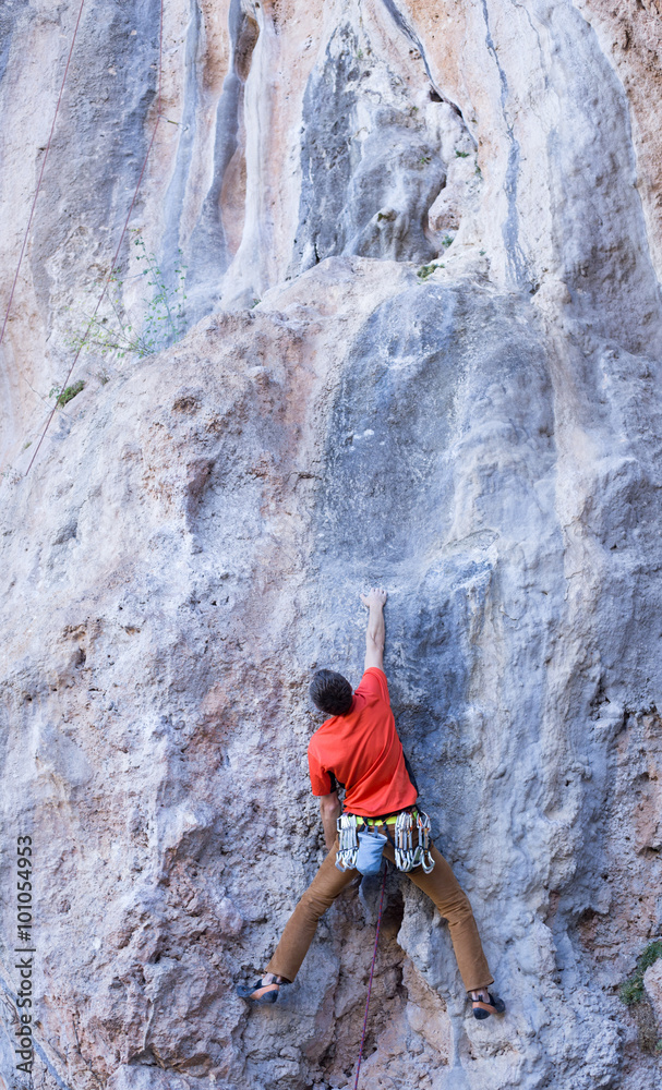 Young male climber hanging by a cliff Young male climber hanging by a cliff
