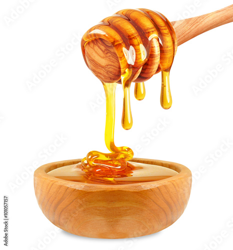 honey dripping on the wooden spoon isolated on white