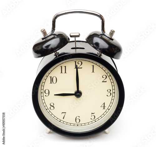 black classic simple alarm clock with beige dial showing almost nine o'clock isolated on white background front top view