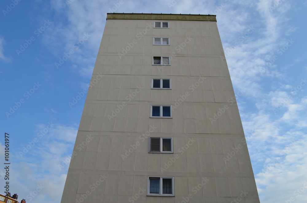 Yellow apartment building against blue sky with clouds Yellow apartment building against blue sky with clouds