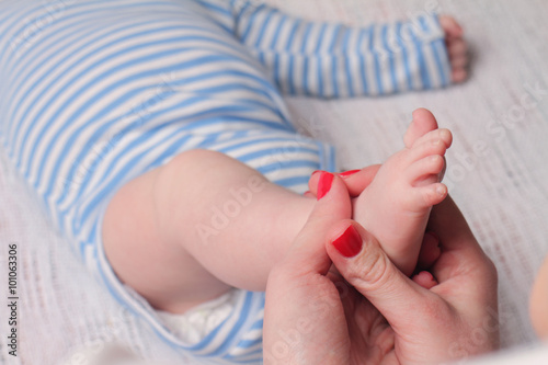 Mother holding baby boy's foot