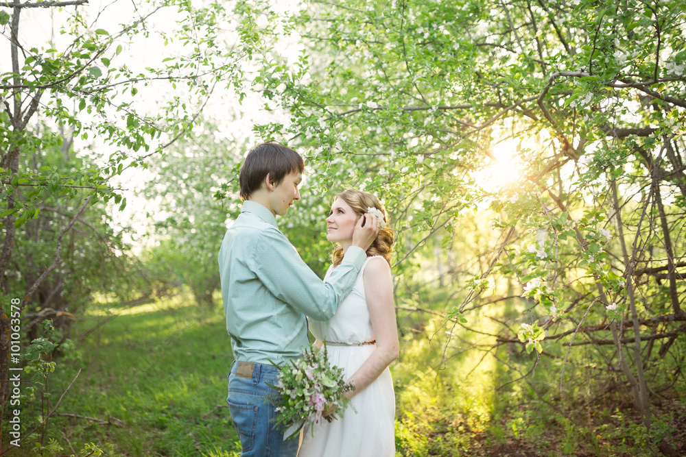 Love couple standing among blooming apple tree Love couple standing among blooming apple tree
