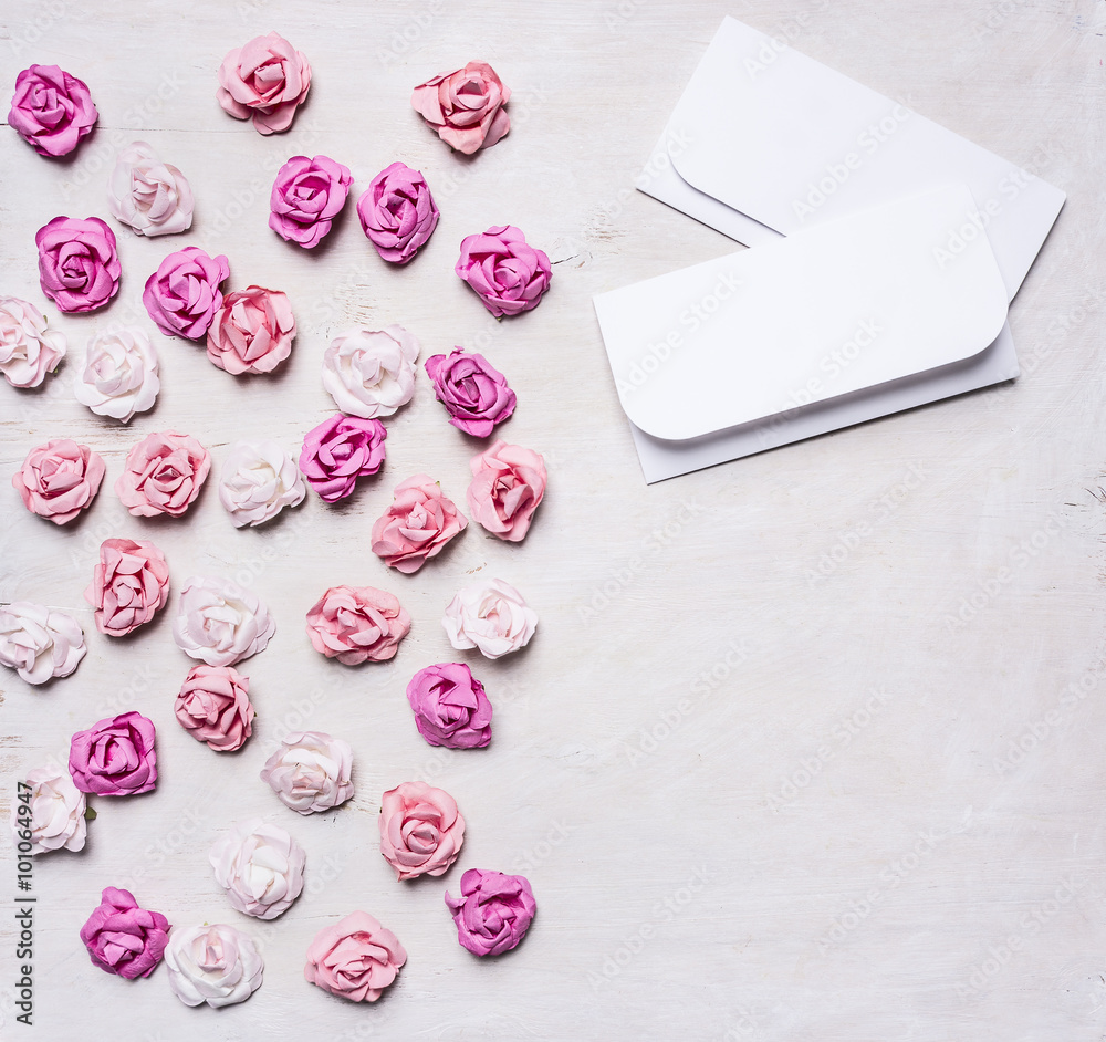 colorful paper roses with envelopes, Valentine's Day border ,with text area  on white wooden rustic background top view close up