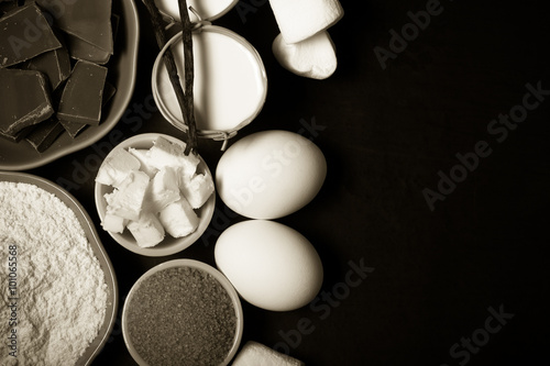 Ingredients for sweet pastry on a black wooden background. Toned