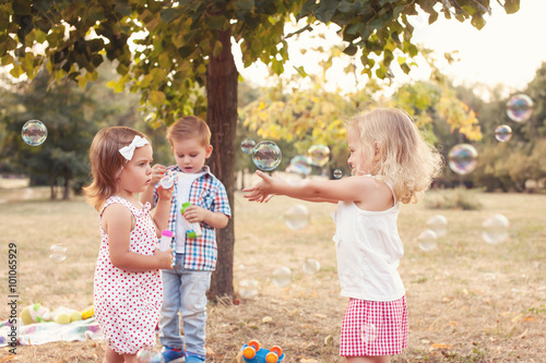 Toddlers playing with bubbles at the park