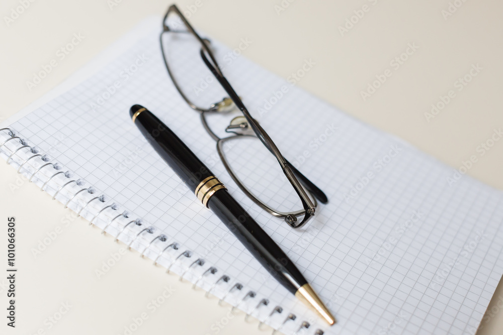 black pen and glasses with white pad or notepad black pen and glasses with white pad or notepad
