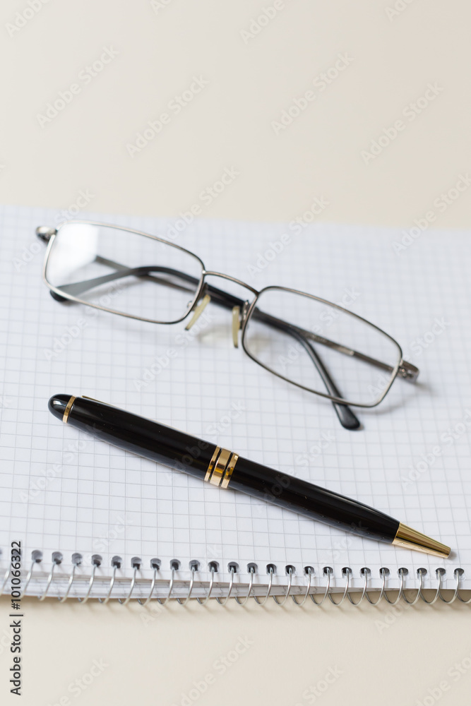 black pen and glasses with white pad or notepad black pen and glasses with white pad or notepad