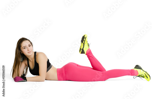 Young athletic woman is laying on a floor, isolated on white