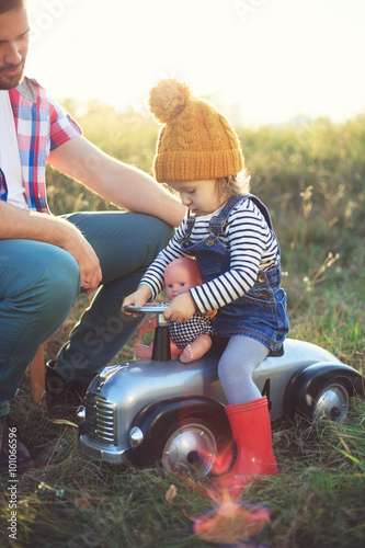 Toddler and father playing with toy in the garden