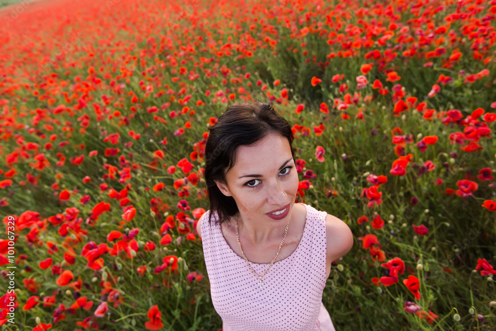 Naklejka premium Girl at blooming poppy field