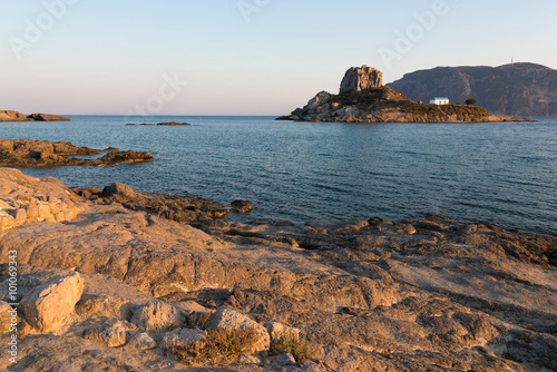 Landscape with rocky coastline and islet at sunset in Kos island, Greece