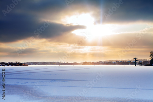 frozen small river a sun lights on horizon