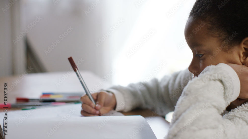 Young girl using coloured pens in her colouring book Young girl using coloured pens in her colouring book