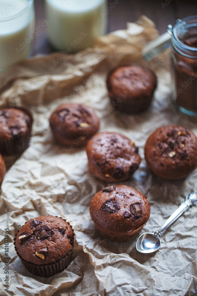 Glass of milk and chocolate cupcakes on a wooden background Glass of milk and chocolate cupcakes on a wooden background