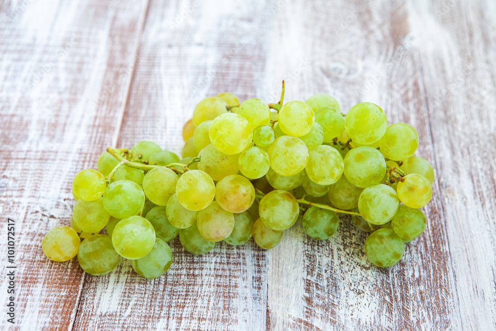 Green and purple round grapes on old wooden table, selective foc Green and purple round grapes on old wooden table, selective foc