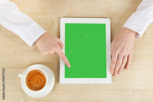 Hands working in the office with tablet-pc, on wooden table