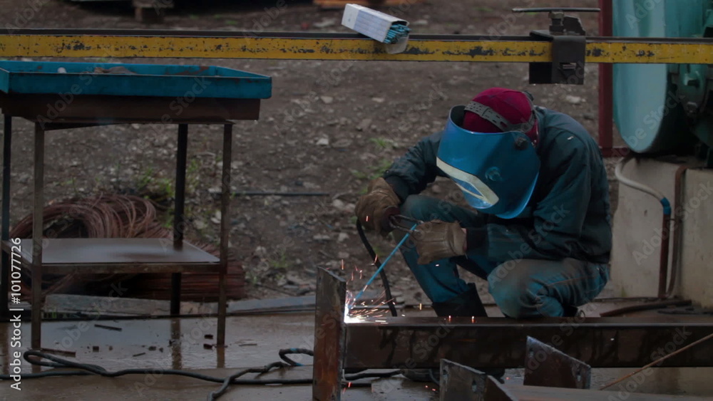 Worker welds metal for construction Worker welds metal for construction