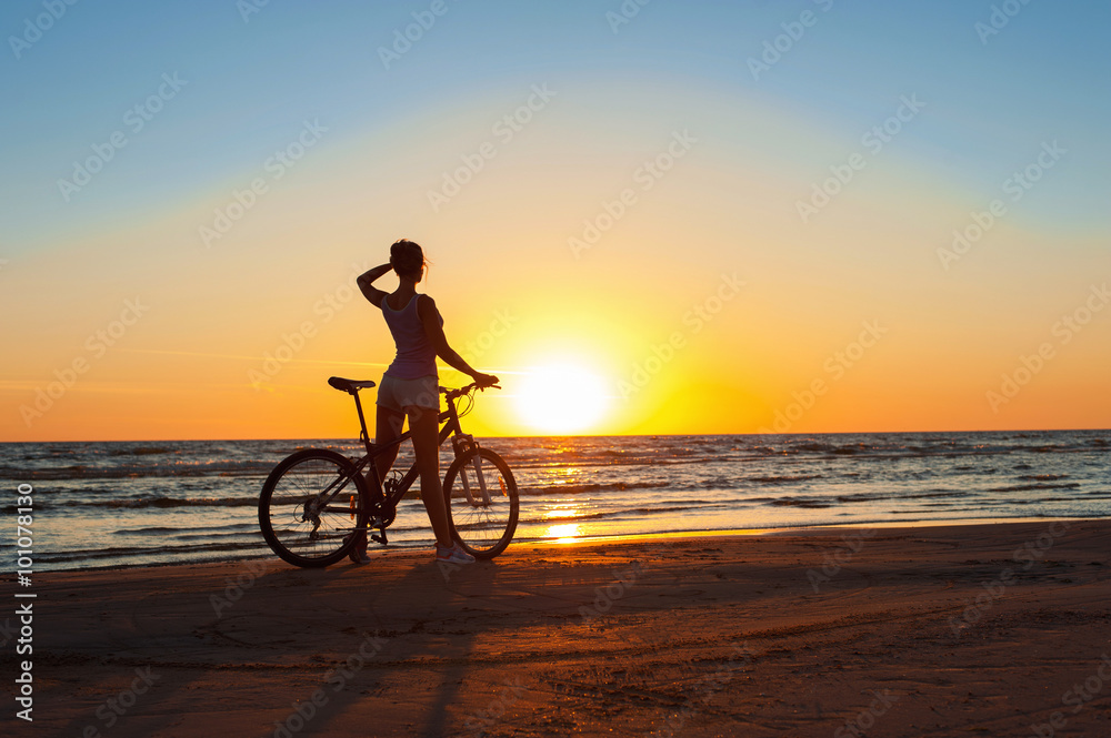 Fototapeta premium Moment in time. Sporty woman cyclist silhouette on multicolored
