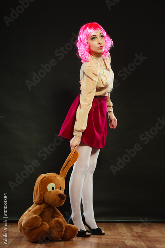 фотографія childlike woman with dog toy on black