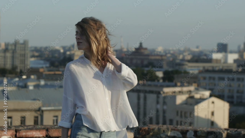 Girl with flying hair posing for the camera on the roof of the building. Girl with flying hair posing for the camera on the roof of the building.
