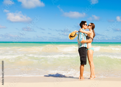 Young couple kissing on a beautiful beach in Hawaii. 