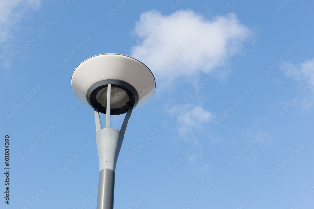lamp post and fluffy clouds in blue sky . lamp post and fluffy clouds in blue sky .
