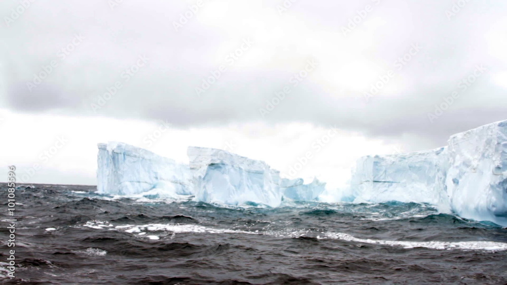 Tabular iceberg floating in rough seas of Drake Passage near Antarctica. Tabular iceberg floating in rough seas of Drake Passage near Antarctica.