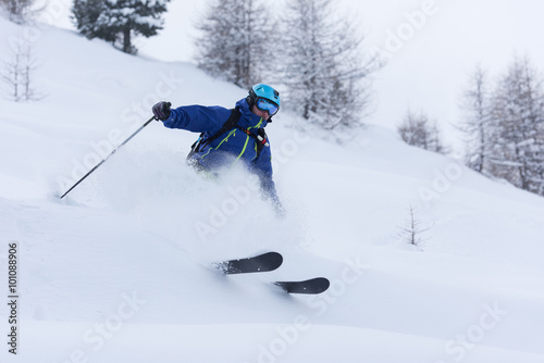 freeride skier skiing in deep powder snow