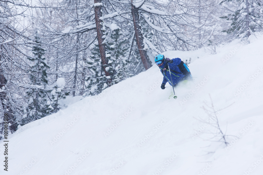 freeride skier skiing in deep powder snow