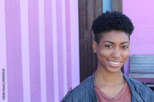 Pretty short hair girl with gray jacket posing against a fancy pink wall