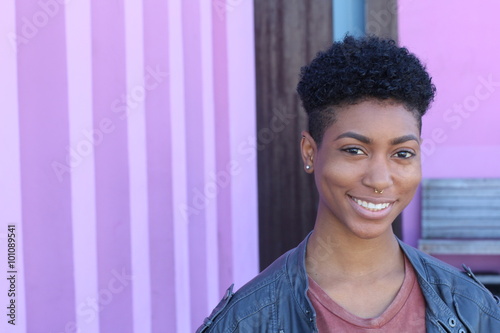 Pretty short hair girl with gray jacket posing against a fancy pink wall photo