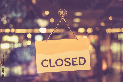 Vintage tone of :A closed sign hanging in a shop window