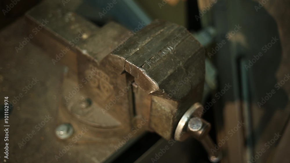 The man clamps a vise mounted on a workbench
The man clamps a vise mounted on a workbench