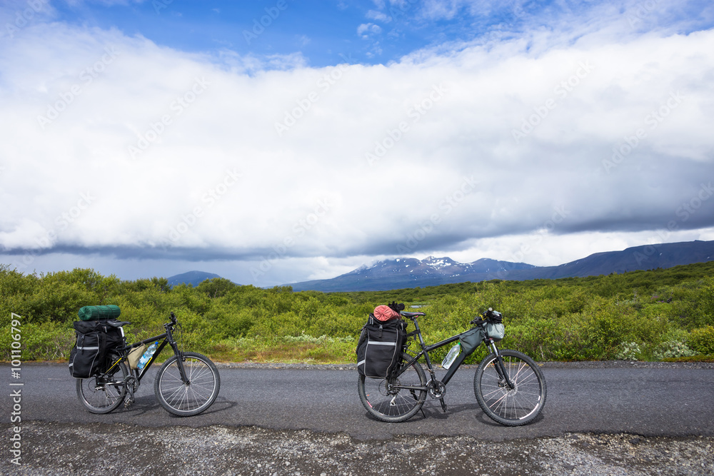 Biker rides on road at sunny summer day in Iceland