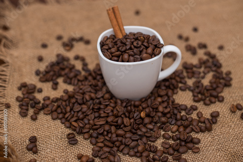 coffee beans and cinnamon white cup and saucer on a table brown texture units large lot of grain