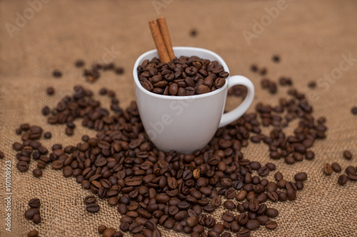 coffee beans and cinnamon white cup and saucer on a table brown texture units large lot of grain