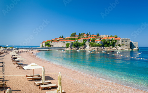 Sveti Stefan luxury sand beach with chaise-longue chairs and umbrellas