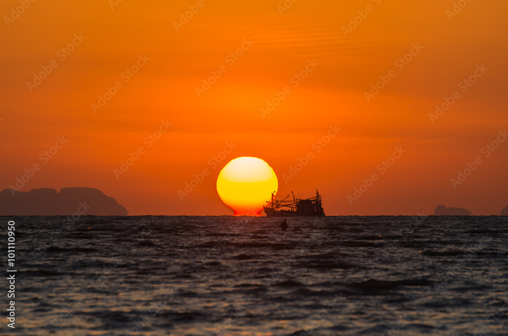 Sunrise with boat silhouette unfocused