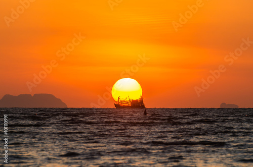 Fototapeta Naklejka Na Ścianę i Meble -  Sunrise with boat silhouette unfocused