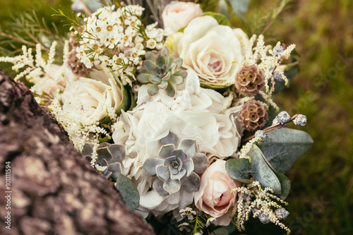 roses, succulents and other flowers in wedding bouquet on green
