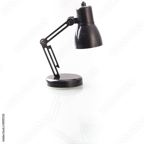 Schwarze Miniatur Lampe auf weissem Tisch, Freisteller mit leich